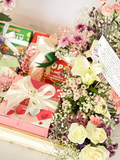 Another detail shot of the anniversary hamper, focusing on the elegantly wrapped gifts and the lush floral arrangement.