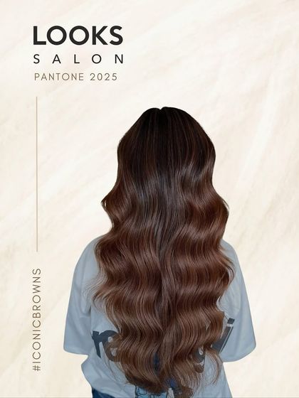 A graphic from our "Iconic Browns" campaign, showcasing a beautiful example of a rich, chocolate brown color on long, wavy hair.