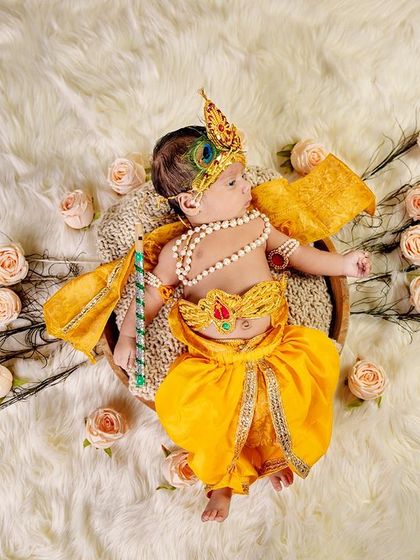 A creative composition using peacock feathers to frame the baby, creating a fan-like effect. We love getting artistic to make your baby's photos truly unique.
