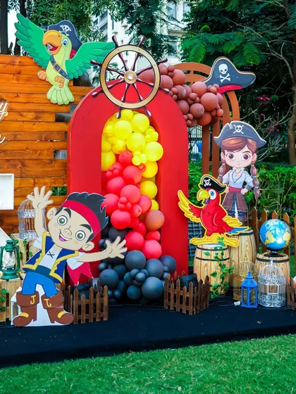 The pirate section of the stage, complete with a ship's wheel, parrots, and treasure barrels.