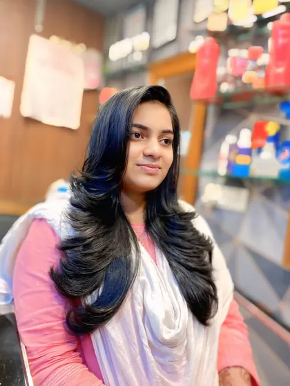 A beautiful, long layered haircut that maintains length while adding volume. The side-swept front and soft waves create a timeless and elegant look.