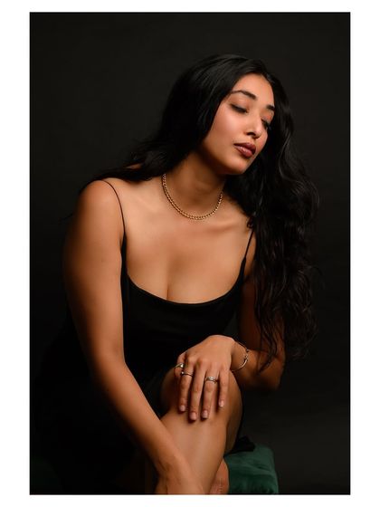 A simple and elegant portrait against a dark background. The focus is on the model's serene expression and natural beauty.
