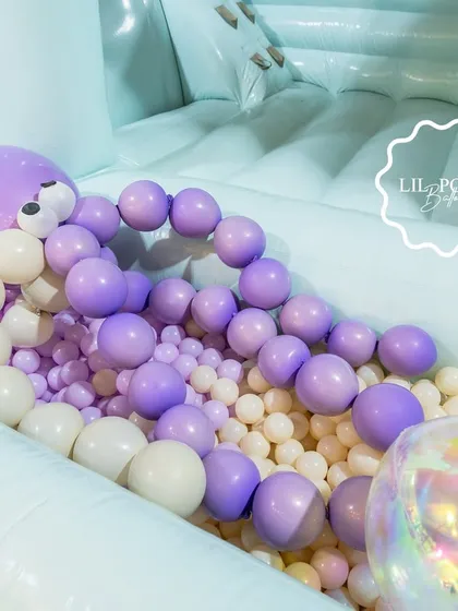 The ball pit of the bouncy castle, filled with purple and white balls and an inflatable octopus.
