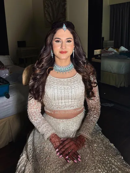 A beautiful sangeet bride in an elegant white lehenga. I created a soft glam look with a focus on radiant skin and defined eyes, complemented by voluminous curls and a delicate maang tikka.
