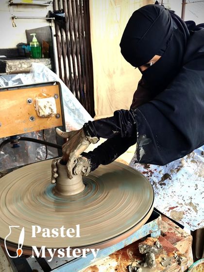 A participant, fully engaged, works on the pottery wheel. This image captures the quiet focus and artistry that happens during our sessions.