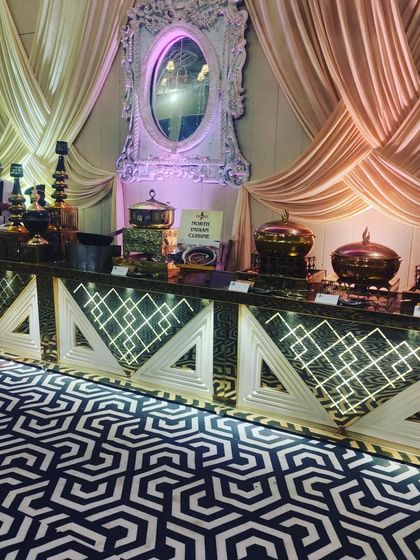 My North Indian cuisine station, set against a backdrop of beautiful drapes. The illuminated counters and traditional brass serving dishes create a warm and inviting look.