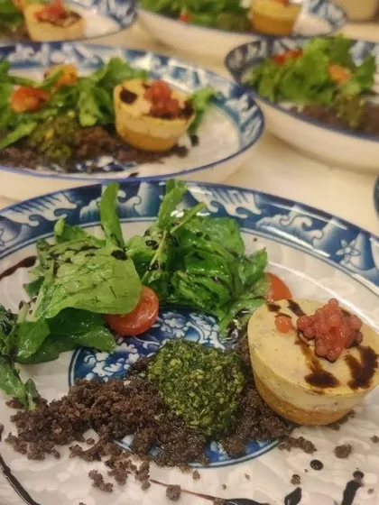 A savoury Balsamic & Herb Baked Cheesecake with olive soil and raspberry caviar. This unique dish plays with sweet and savoury notes, perfect for an adventurous palate during a multi-course dinner.