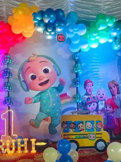 A detailed shot of the Cocomelon backdrop and balloon arch.