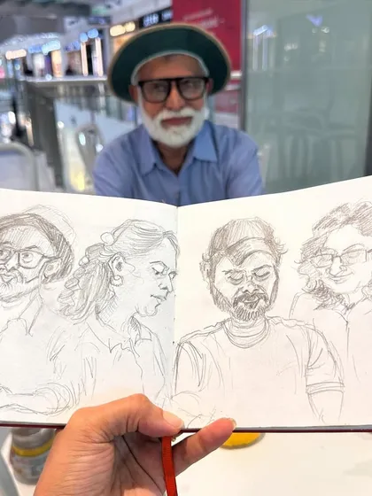 Here's my friend and fellow artist Shrikant holding up my sketchbook, which features pencil portraits of him and other artists. Sketching my peers is a great way to practice and share our love for art.