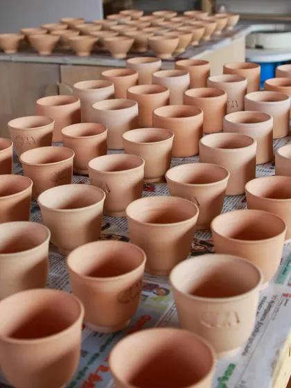 The studio is often filled with greenware for large production orders. These tumblers and bowls are drying on the shelves, waiting to be bisque fired and glazed for a client.
