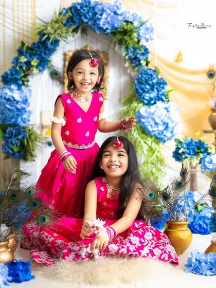 Two sisters having fun during their Janmashtami photoshoot. Their bright smiles and colorful outfits are absolutely infectious.