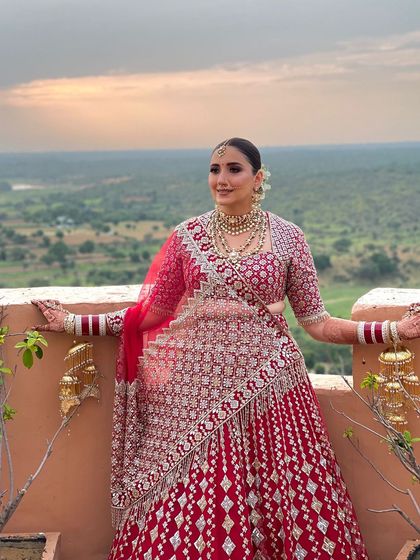 The bride against a beautiful backdrop. Her classic floral bun hairstyle is perfect for this destination wedding, looking both elegant and timeless.
