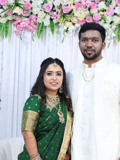 The happy couple at their engagement. Her makeup is soft and radiant, complementing his classic white outfit perfectly.