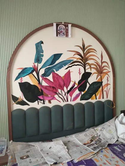 The tropical mural in progress, showing the initial color blocking and composition above the upholstered headboard.