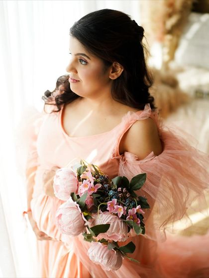 A close-up portrait highlighting the delicate details of the gown and the mother's serene expression.