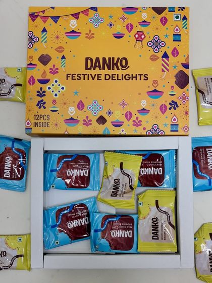 This version of the Danko Festive Delights box contains 12 pieces of assorted chocolates, packed in a clean white tray inside the festive yellow box.