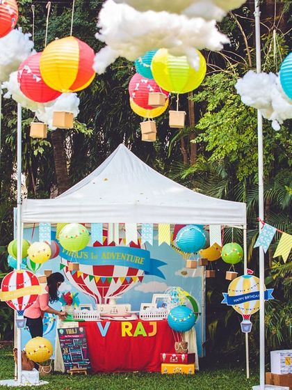 A hot air balloon-themed first birthday in a garden setting. The hanging lanterns designed as hot air balloons created a whimsical and adventurous atmosphere.