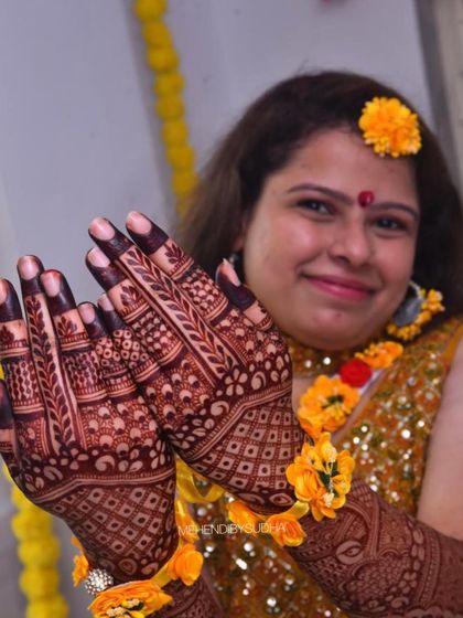 A happy bride admiring her deep henna stain. The joy on her face reflects the beauty of the result.