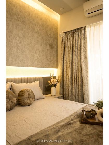 This parent's bedroom features a textured accent wall with concealed lighting, creating a soft, ambient glow. The design is simple, elegant, and incredibly calming.