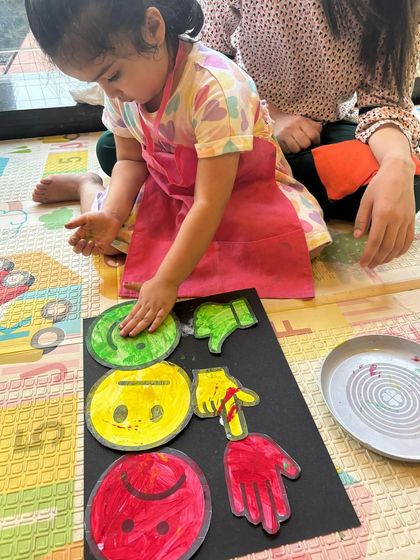 This activity combined learning about traffic signals and emotions. The children used handprints and painted faces to show happy, sad, and go/stop signals, making it a fun social-emotional learning exercise.