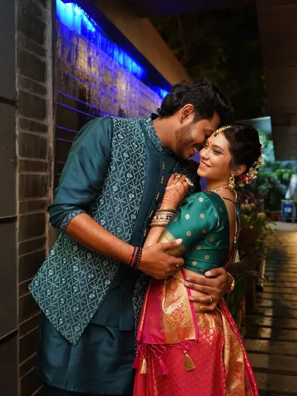 An intimate embrace against a modern backdrop with blue lighting, showcasing a couple's romantic connection.