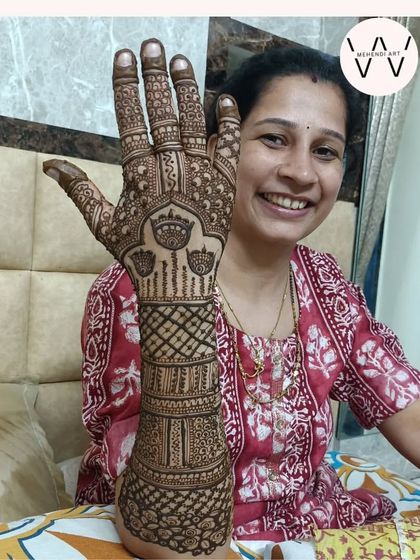 A happy client showing her full-hand henna design.