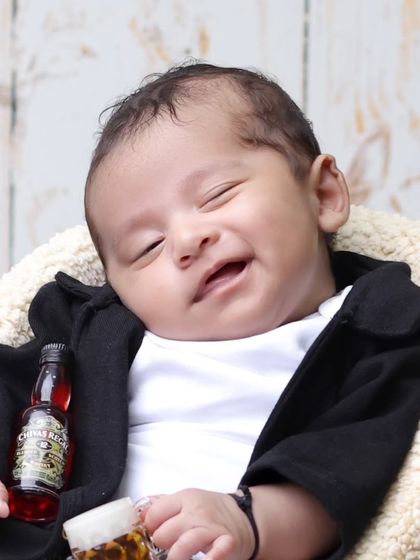 A cheeky smile from our little biker. This close-up captures a priceless expression, complete with a miniature bottle for a humorous touch.