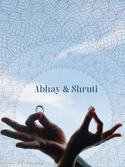 An artistic shot of the couple's hands holding their rings against the sky, framed by a mandala design.