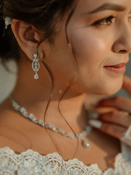 A close-up on the details: the delicate diamond jewelry and the soft, glowing skin of the bride.