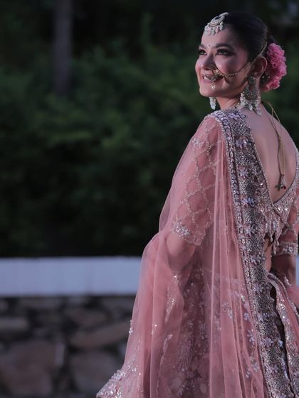 A candid shot showing the back of the blouse and the beautiful floral bun. The makeup is just one part of the complete, cohesive bridal look I help create.