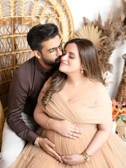 A tender moment in our rustic-chic peacock chair set. The couple shares an affectionate kiss, surrounded by warm, earthy tones.