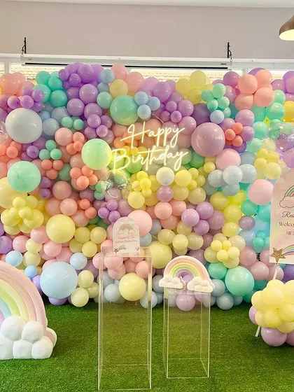 We built this incredible floor-to-ceiling pastel rainbow balloon wall as the centerpiece for Suhani's fifth birthday. The setup is completed with 3D rainbow props and a neon 'Happy Birthday' sign, creating a joyful and picture-perfect backdrop.