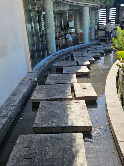 An interesting pathway design with stone slabs over a water channel. We find inspiration in creative and unconventional landscape solutions.