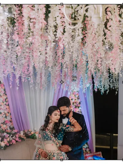 A romantic portrait of the couple at their reception, framed by a stunning ceiling of hanging flowers.