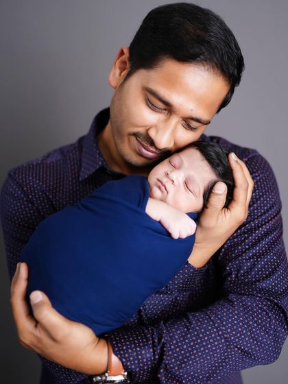 The special bond between a father and his newborn, captured as he holds his sleeping baby close to his chest.