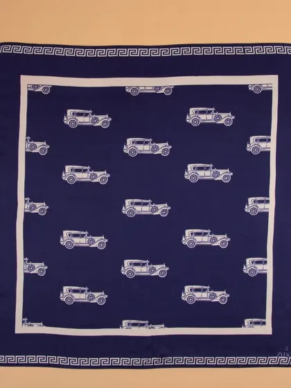 A navy blue pocket square with a vintage car print, shot flat to display the entire design.
