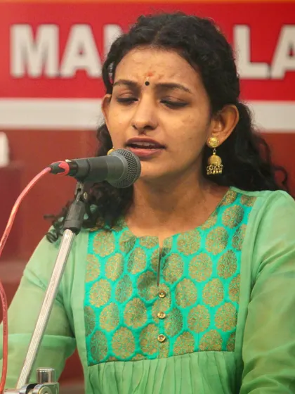 A student's soulful rendition during the temple performance. The serene expression reflects the devotional nature of the music.