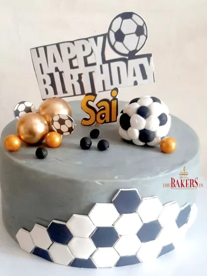 A stunning no-fondant cake for Sai, who is a big football fan. The grey cake is accented with a black and white hexagon pattern, and the fondant footballs add a fun, thematic touch.