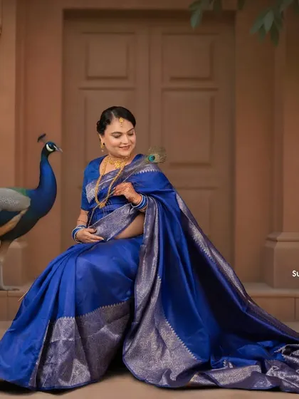 A majestic portrait featuring a live peacock, adding a touch of royal splendor to this blue saree maternity shoot. We can arrange for unique props to make your session special.