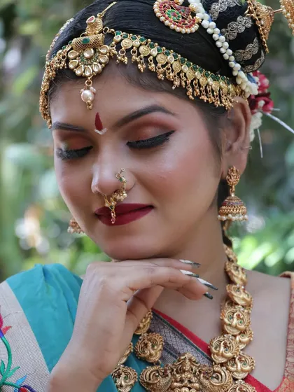 A gentle and demure pose, highlighting the traditional nose ring and the rich red lip color.