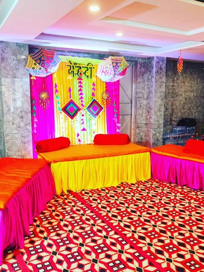 The main seating area for the Mehendi ceremony, with a decorated divan and comfortable floor seating for guests.