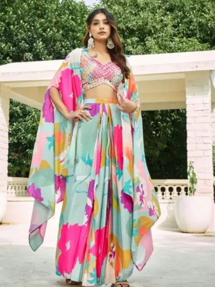 This Indowestern outfit features a stunning multi-color floral print on a draped skirt and matching cape. It's a fresh, modern, and vibrant choice for a day wedding or mehendi.