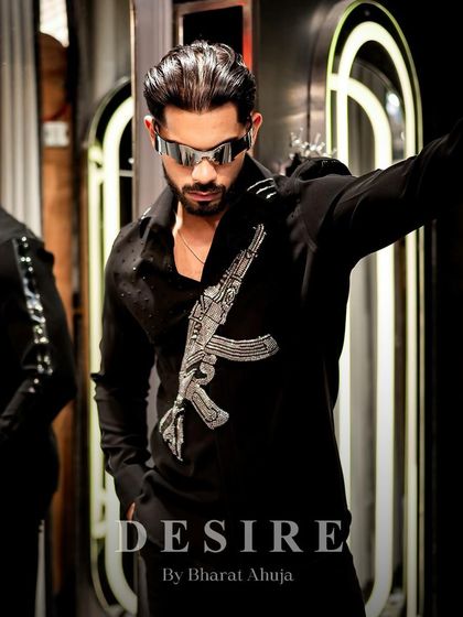 Laced in luxury. This shot captures the rebellious spirit of the gun-embroidered shirt, a piece that is designed to make a powerful statement.