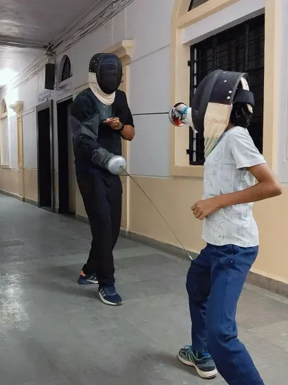 A practice bout between two young fencers during the summer camp. This controlled sparring allows them to apply the techniques they've learned in a real match situation.