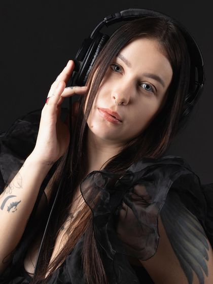 Another portrait of the DJ against a black background, creating a low-key, intimate feel that focuses on her connection with the music.