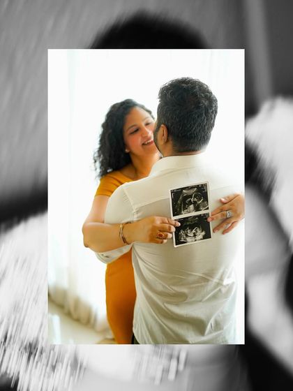 A creative shot with a black and white filter, focusing on the sonogram pictures held against the partner's back.