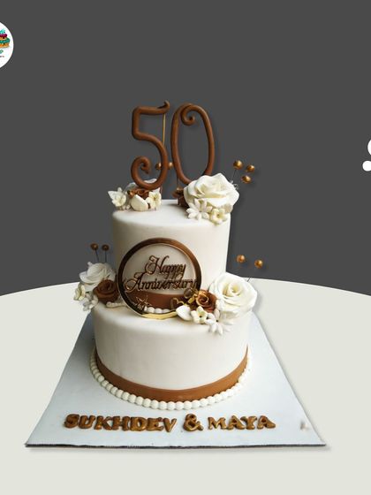 Celebrating 50 years of togetherness with this classic two-tiered anniversary cake. The design features elegant white and brown tones, delicate sugar flowers, and a custom topper marking the golden milestone.