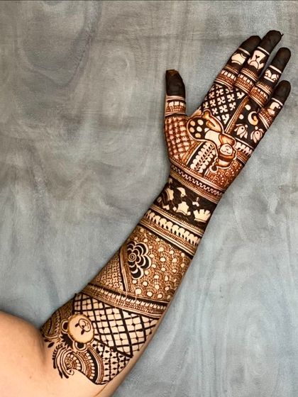 A unique baby shower design that extends onto the upper arm. It features a teddy bear, baby blocks, and other playful elements.