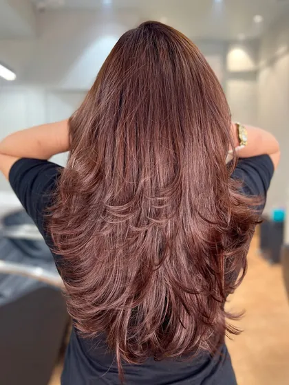 A stunning mahogany brown global color paired with a layered haircut. This look is sophisticated and vibrant.