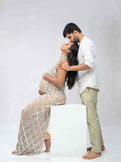 A moment of pure elegance. He lovingly embraces her as she sits gracefully in the stunning embellished gown.